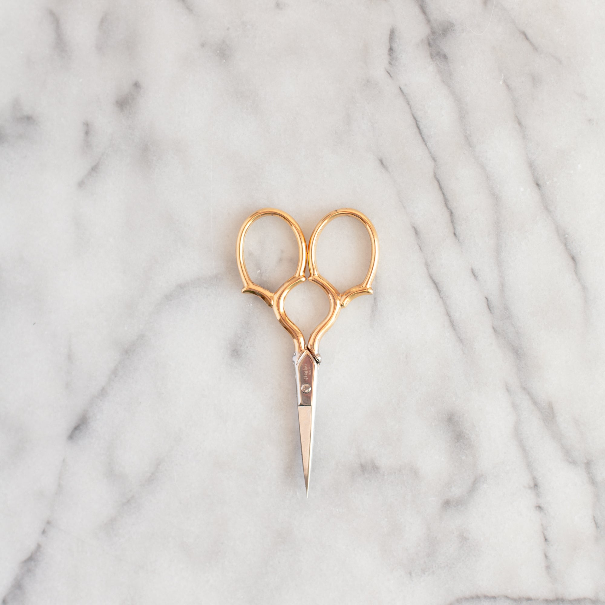 3.5" gold handled embroidery scissors on marble