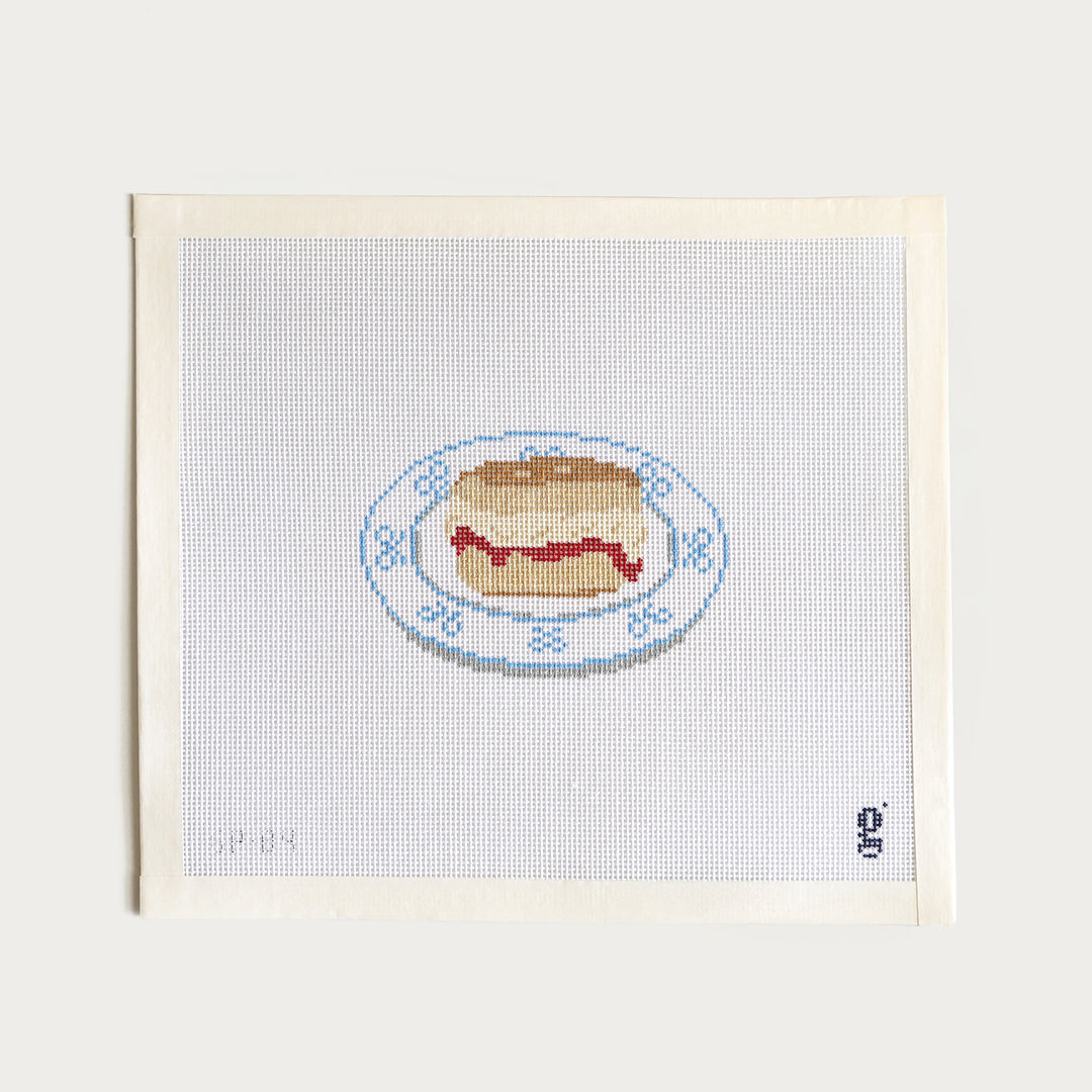 Hand-painted Blue Bow Scone needlepoint canvas, 2.8" x 4.1" on 18 mesh, featuring a scone with a blue bow.