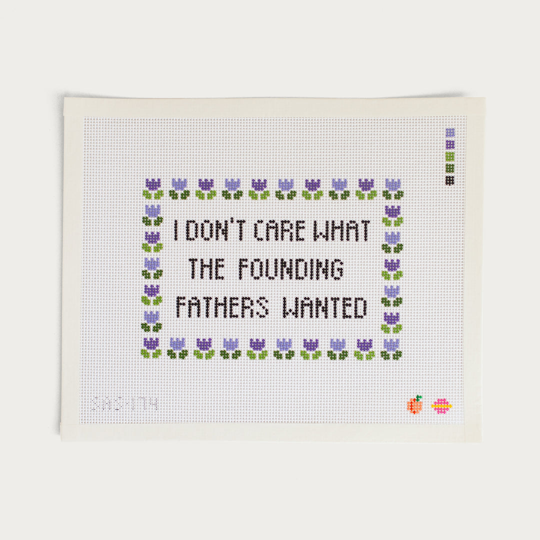 Needlepoint canvas that says "I don't care what the founding fathers wanted" with purple flowers framing the text