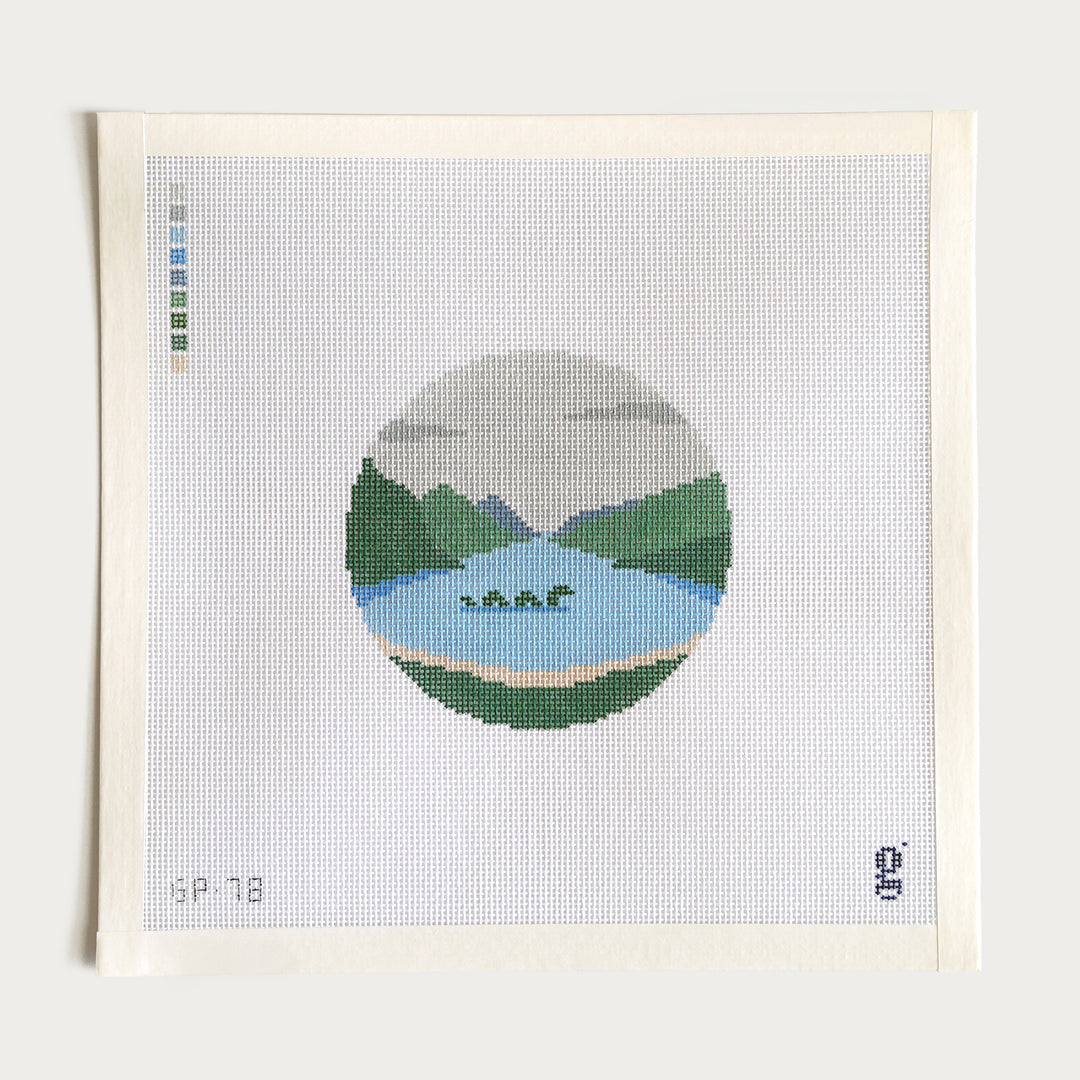 Hand-painted WS Nessie needlepoint canvas featuring the Loch Ness Monster in a Scottish lake, 4” round on 18 mesh.