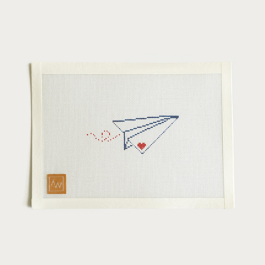 Hand-painted Paper Airplane needlepoint canvas on 18 mesh, measuring 4.5” x 2”, perfect for small projects.