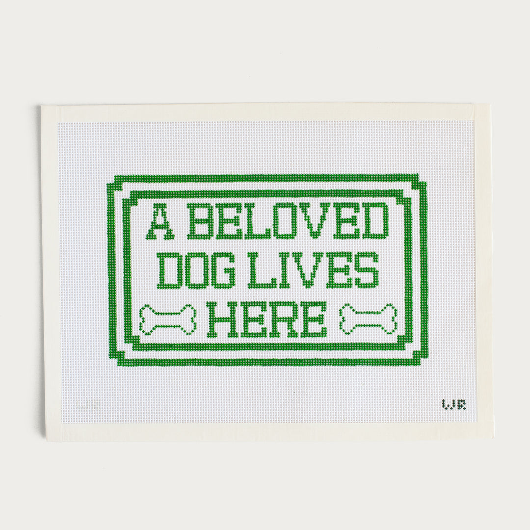 Hand-painted A Beloved Dog Lives Here needlepoint canvas with a pet-themed design.