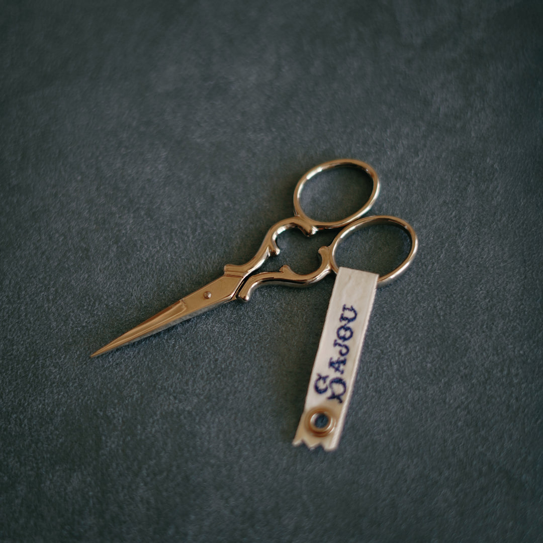 Sajou Nogent embroidery scissors, nickel-plated, 8.9cm with curved handles, presented in a reusable fabric-inspired case displayed on blue Suede.