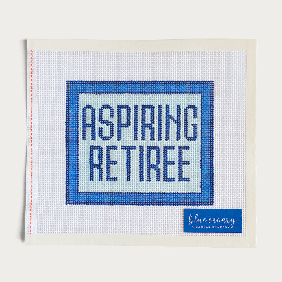 Hand-painted Blue ‘Aspiring Retiree’ needlepoint canvas on 13 mesh, perfect for future retirees.