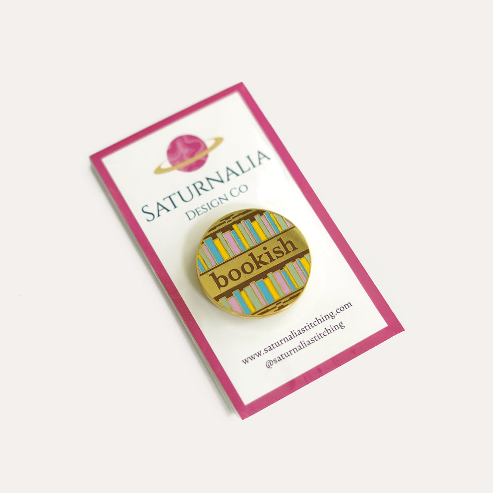 Bookish enamel needle minder with book spines and strong magnet for stitching