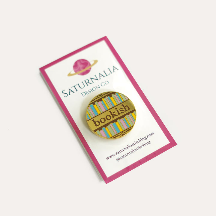 Bookish enamel needle minder with book spines and strong magnet for stitching