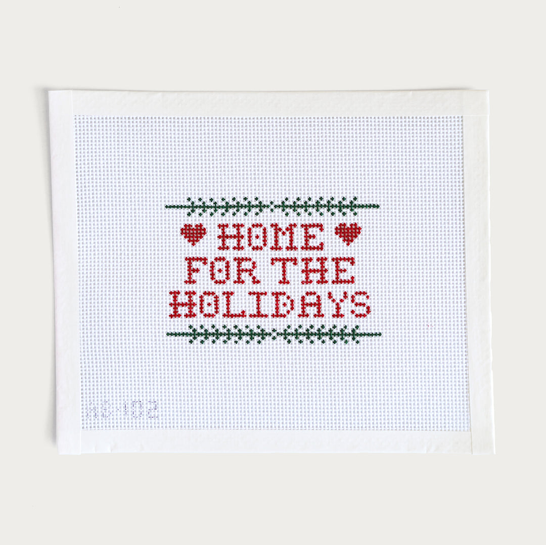 Hand-painted ‘Home for the Holidays’ needlepoint canvas on 13 mesh, featuring a cozy winter scene with festive decorations.