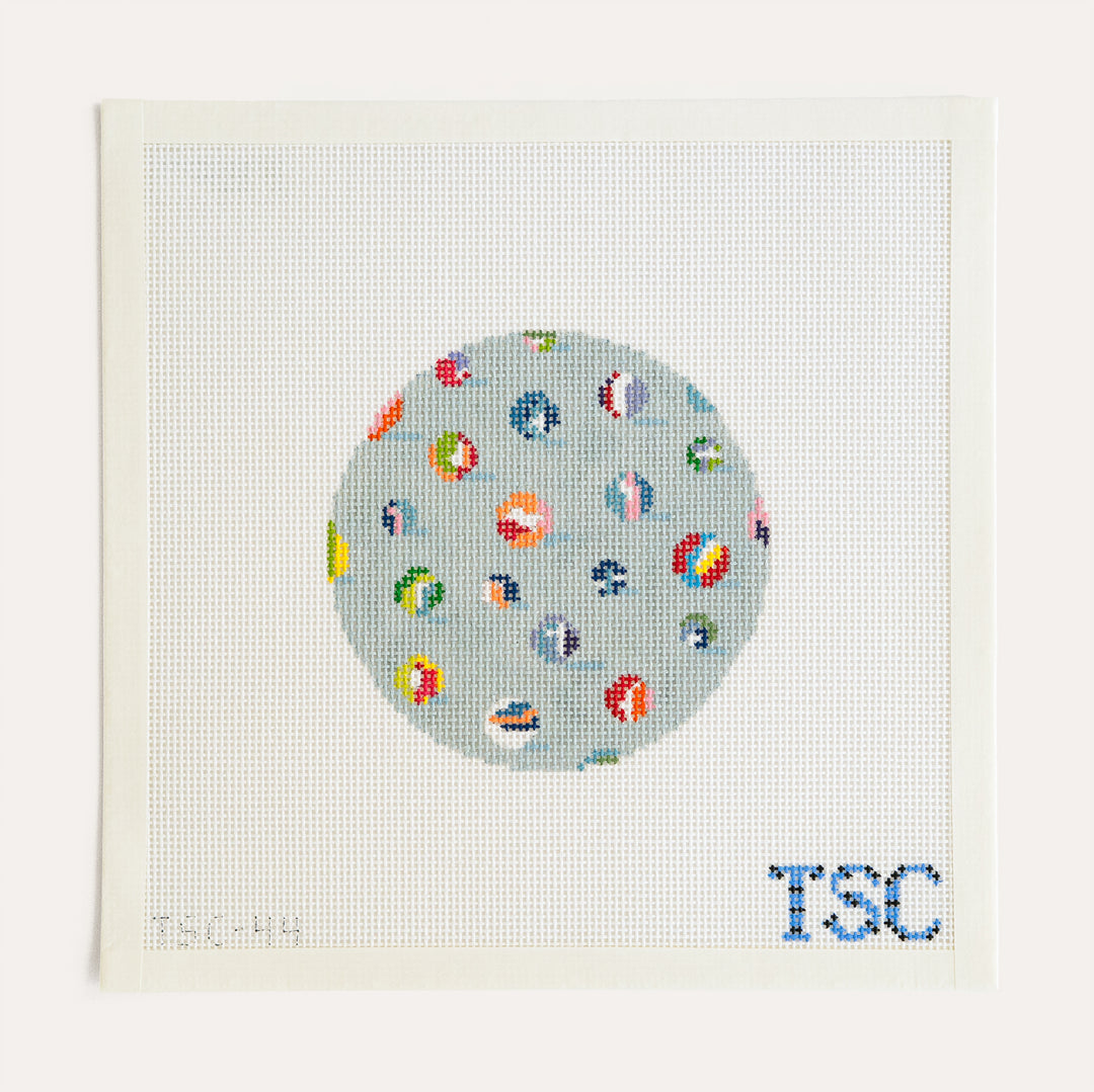 Lost My Marbles Round needlepoint canvas by The Sheffield Collection with colorful marbles on light blue, 13 mesh