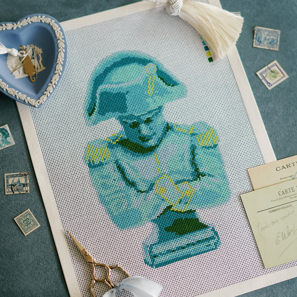 Close-up detail of Napoleon needlepoint bust canvas with blue, aqua, and chartreuse tones