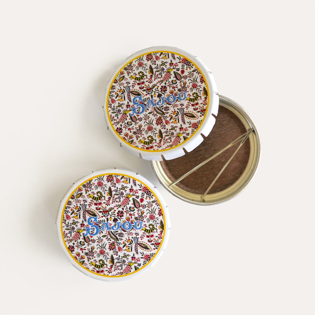 Two Sajou click clack tins, one open with tapestry needles inside, ideal for storing needlepoint supplies