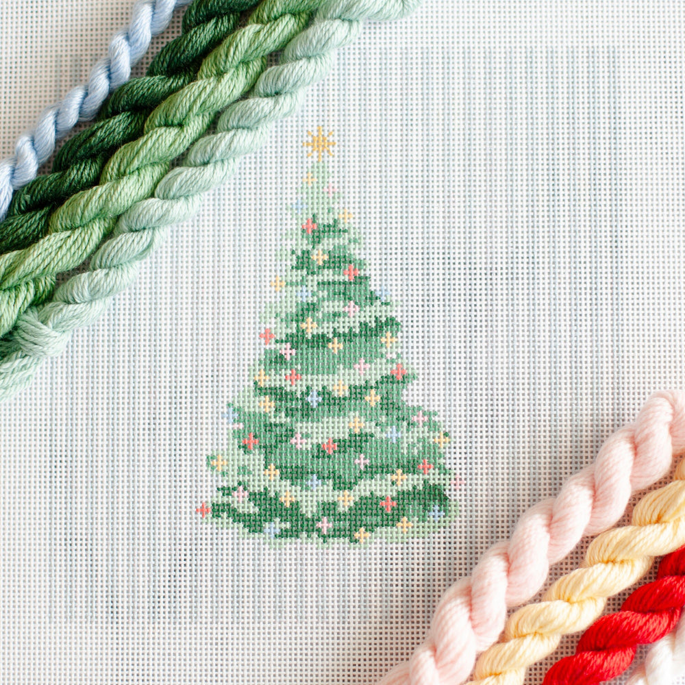 Christmas tree Needlepoint Canvas with a gold star and colorful ornaments on a light blue and white striped background